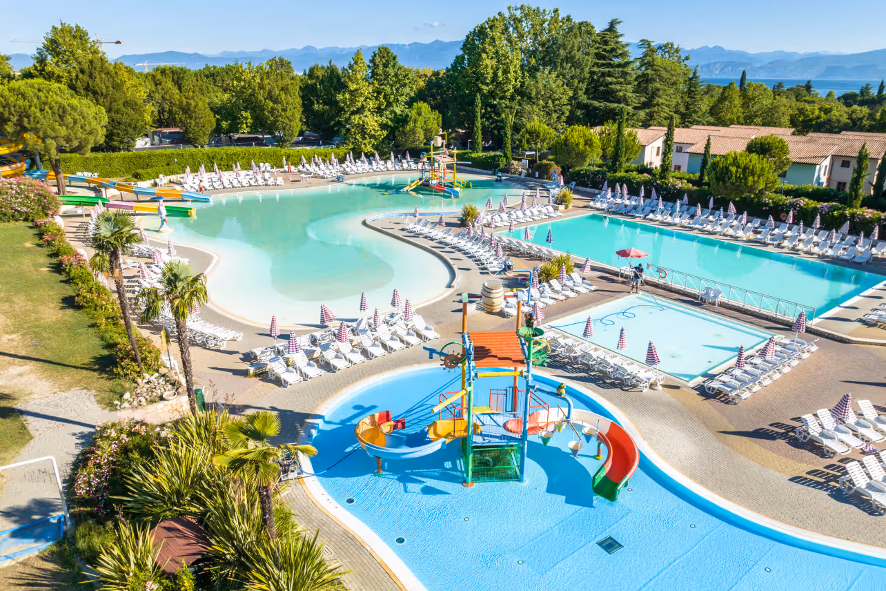Luchtfoto van meerdere zwembaden en het kinderbad van Camping Bella Italia aan het Gardameer