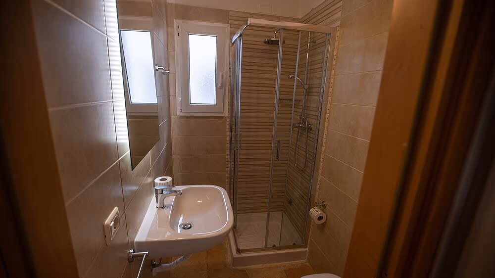 Badkamer met douche en wastafel in appartement Lavanda op Camping Bella Italia