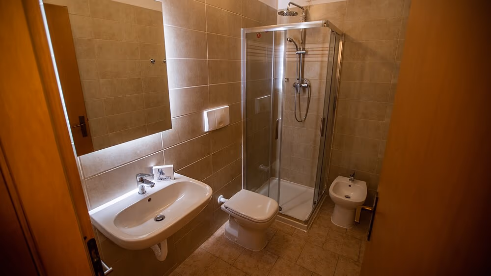 Badkamer met douche, wastafel en toilet in appartement Ortensia op Camping Bella Italia