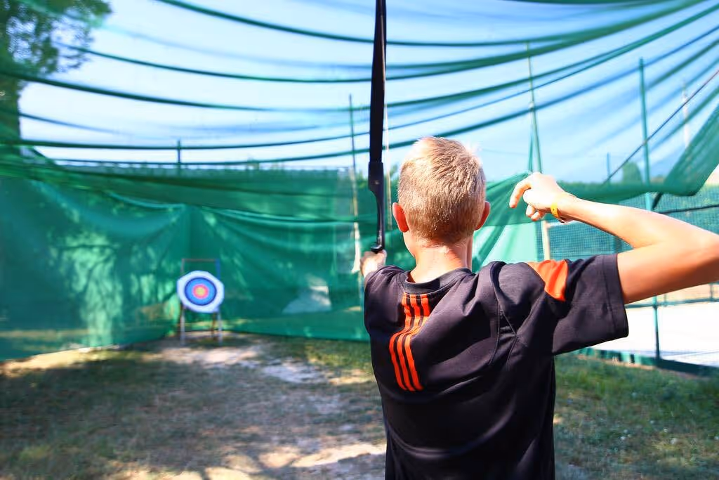 Deelnemer richt met een boog tijdens een sportactiviteit op Camping Bella Italia