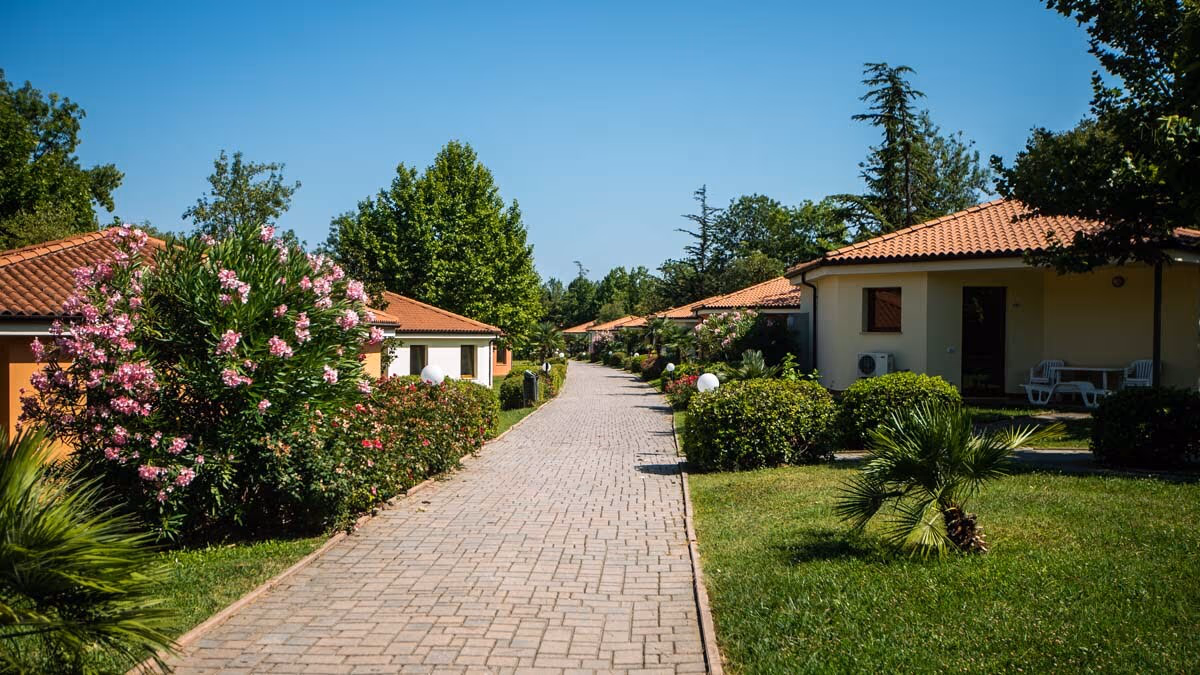 De bungalows Oleandro aan een bloemrijk wandelpad in de autovrije zone van Camping Bella Italia
