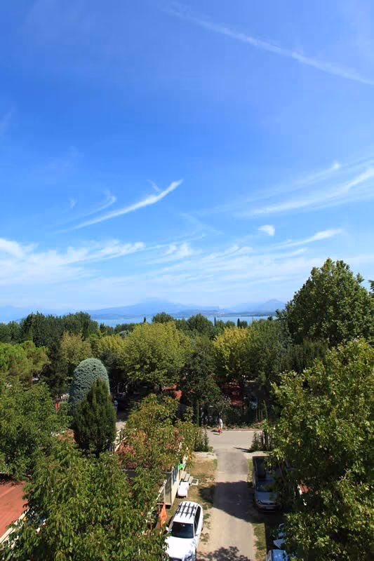 Schaduwrijk voetpad tussen de bomen en de kampeerplaatsen van Camping Bella Italia