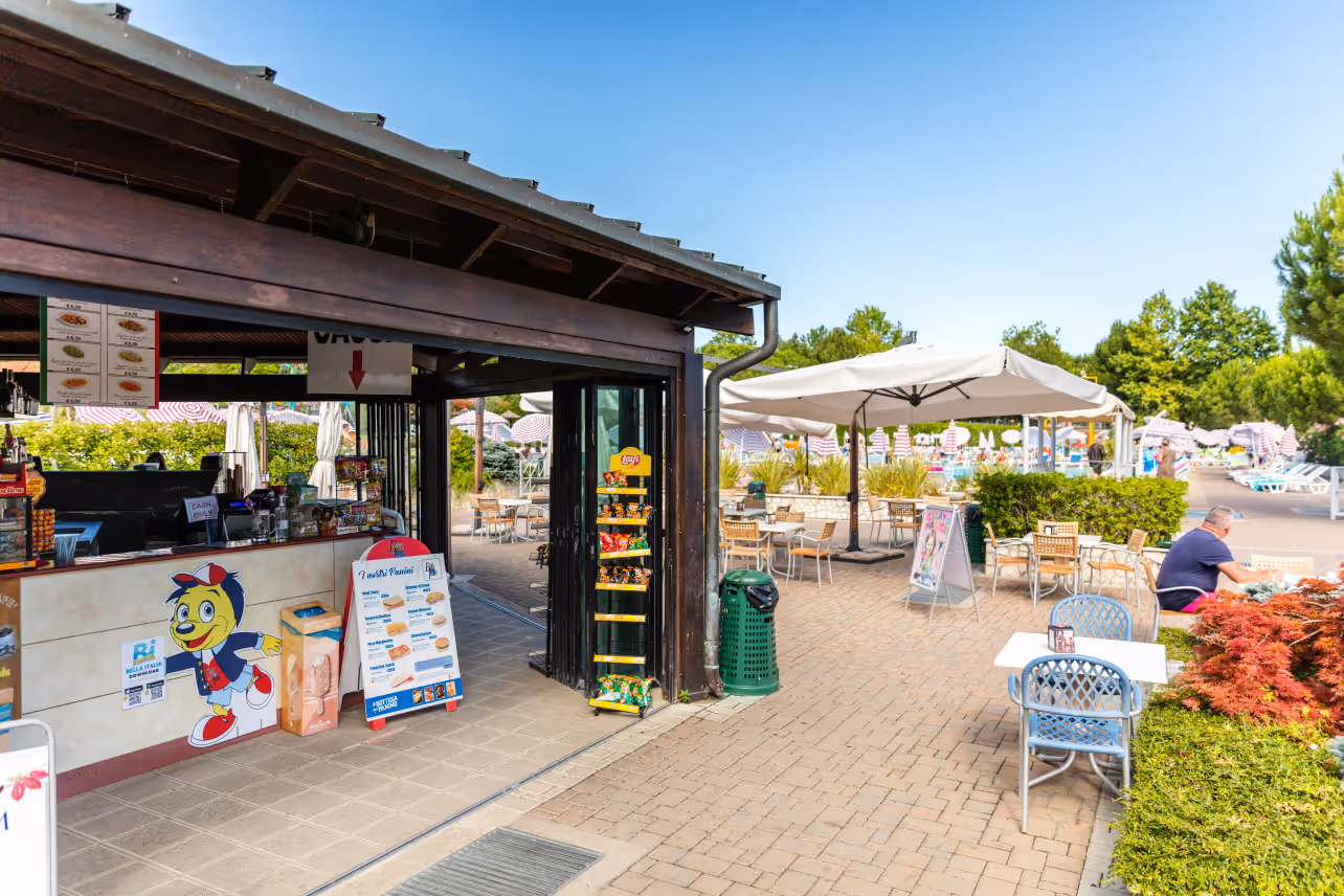Campingwinkel met kiosk en buitenterras op Camping Bella Italia aan het Gardameer
