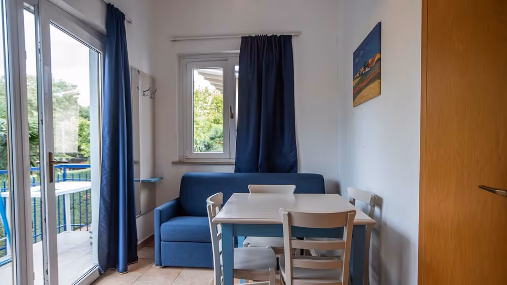 Eethoek bij het raam in een verblijf op Camping Bella Italia