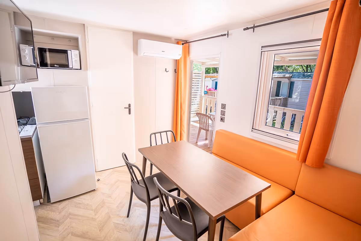 Eethoek met bank in een stacaravan op Camping Bella Italia