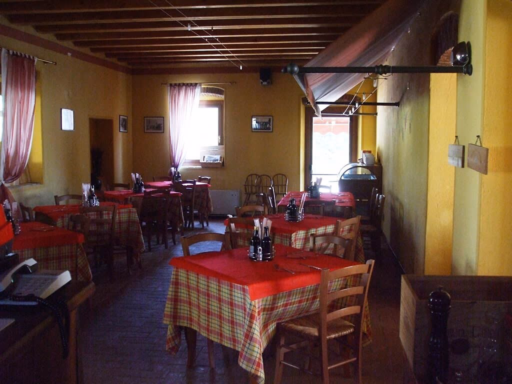 Eetzaal met rood-geruite tafelkleden in een restaurant van Camping Bella Italia
