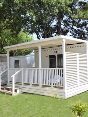 Stacaravan met veranda tussen het groen op Camping Bella Italia