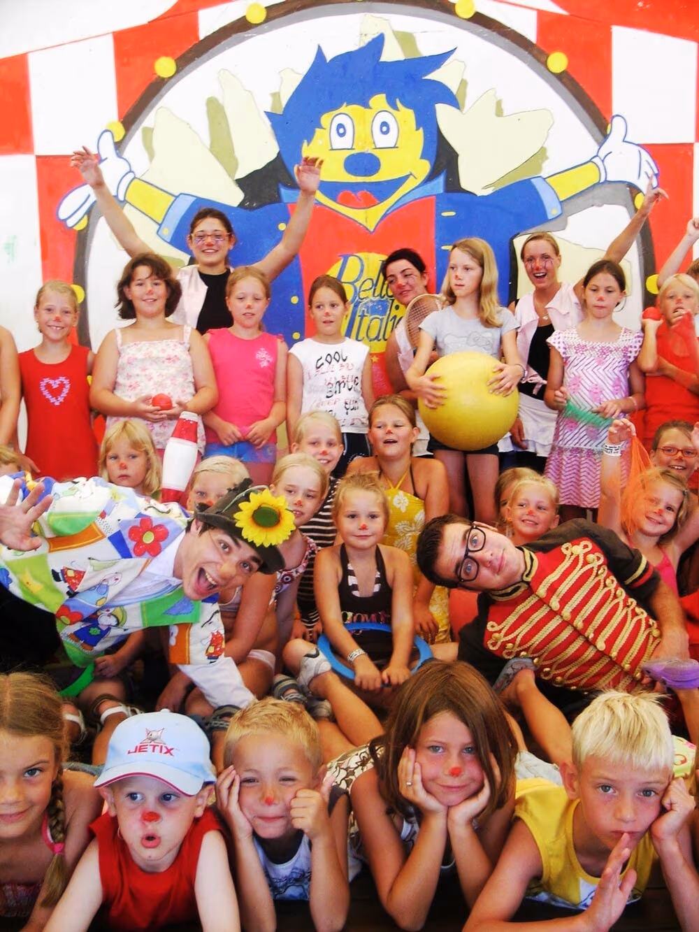Groep kinderen met animatiefiguren tijdens een activiteit van de mini club op Camping Bella Italia