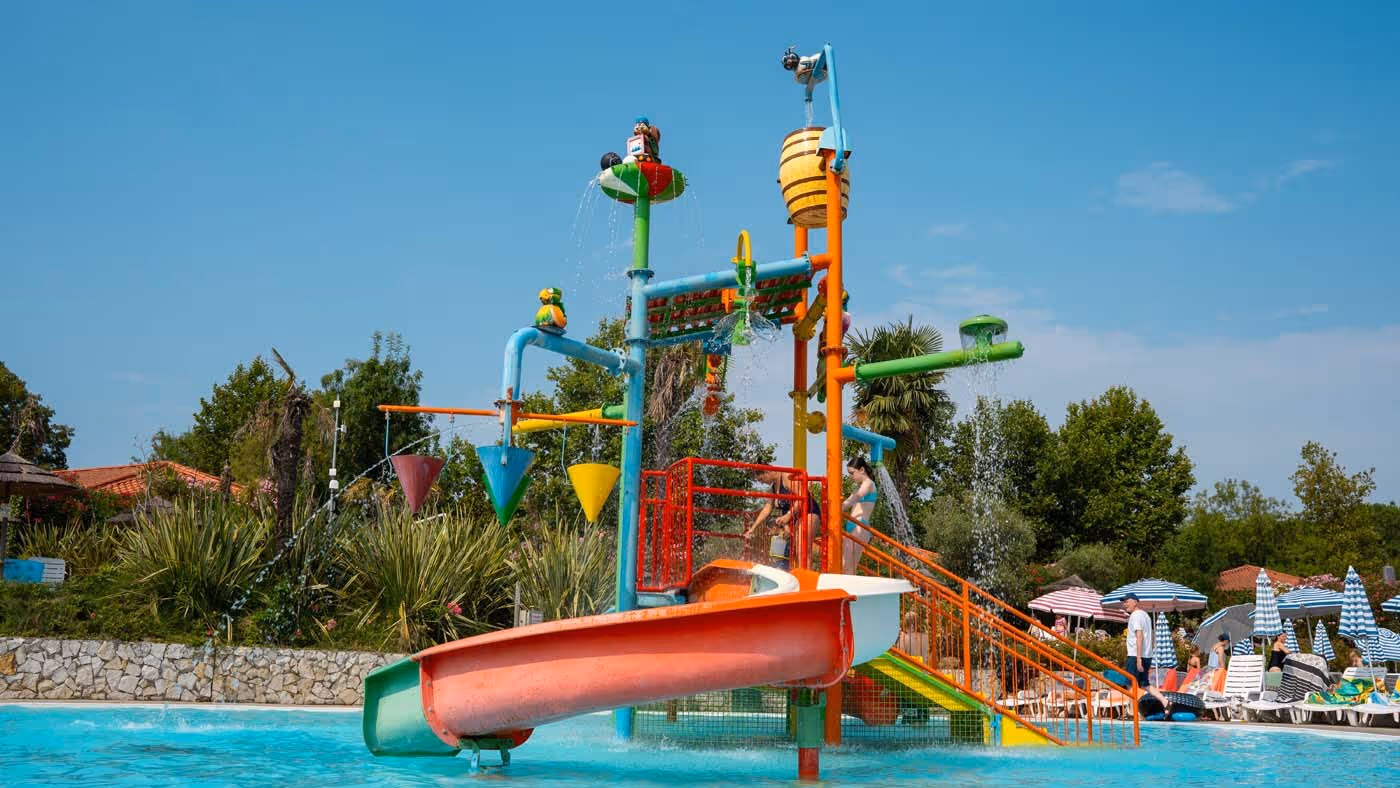 Kleurrijk waterspeeltoestel met glijbanen in het kinderbad van Camping Bella Italia