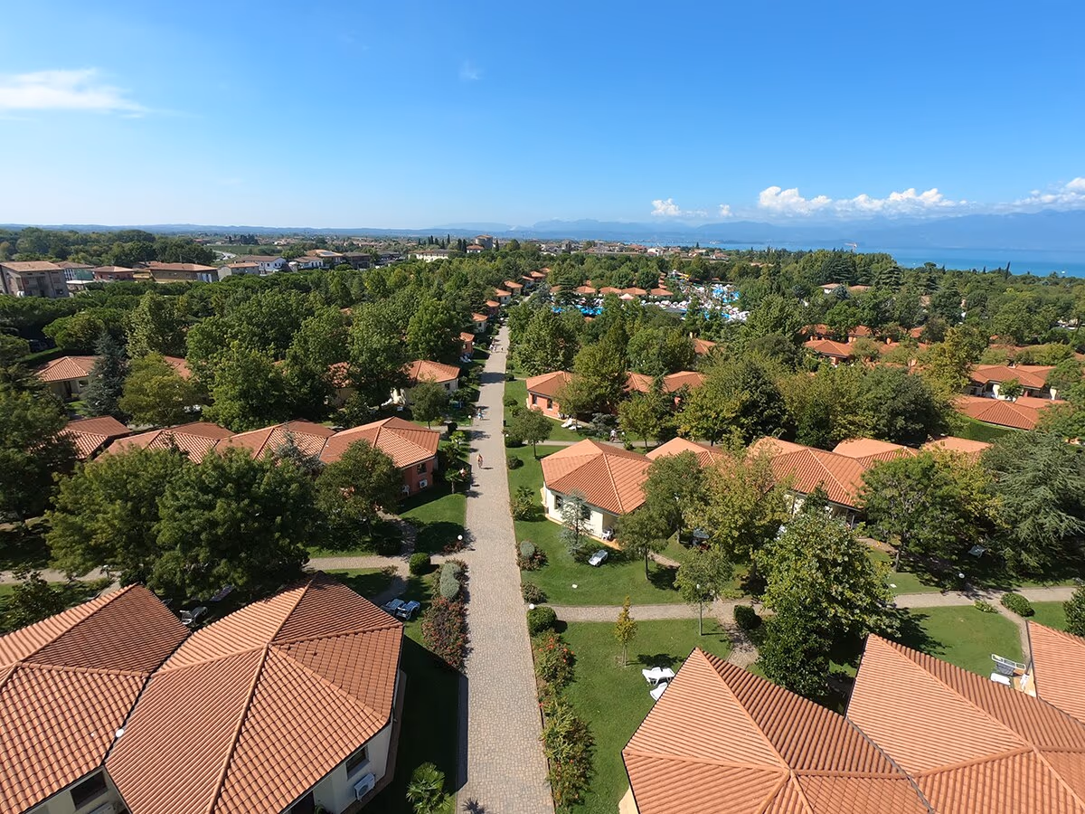 Luchtfoto van rijen vakantiehuizen en een zwembad op Camping Bella Italia