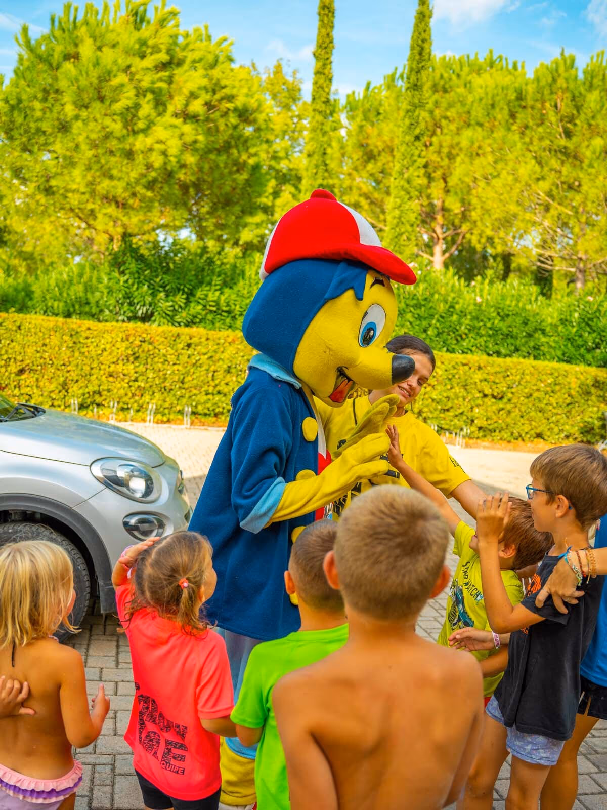 Kleurrijke mascotte begroet kinderen bij de miniclub van Camping Bella Italia