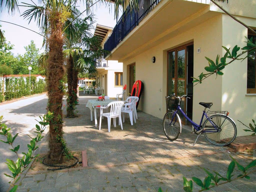 Terras met tafel en fietsen bij een appartement op Camping Bella Italia
