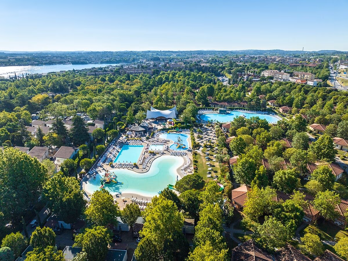 Luchtfoto van de zwembaden, de accommodaties en het Gardameer bij Camping Bella Italia
