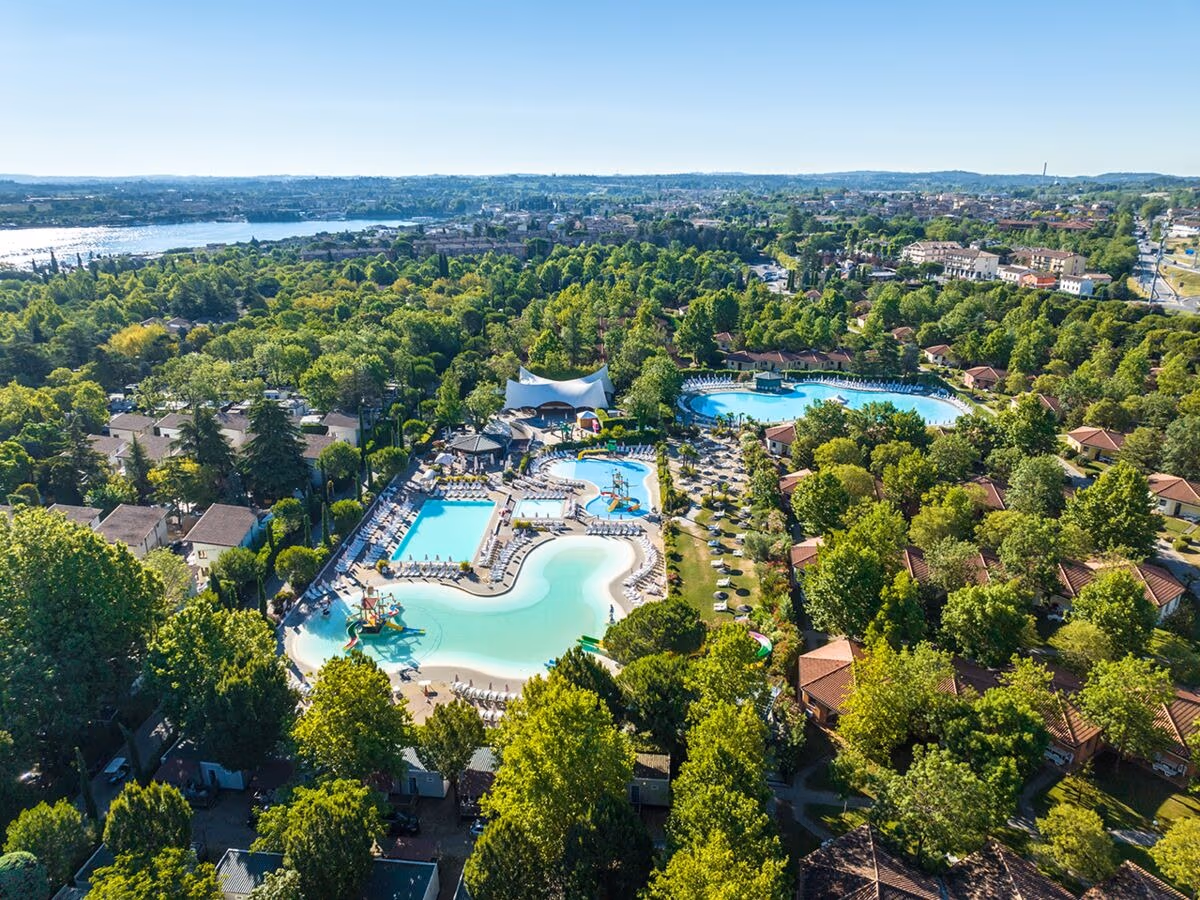 Luchtfoto van de zwembaden, accommodaties en het Gardameer bij Camping Bella Italia
