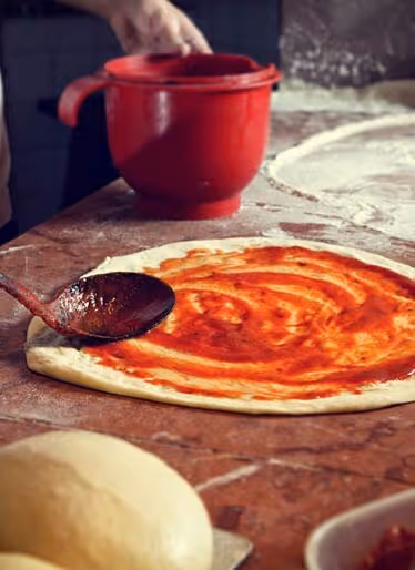 Pizza die met de hand wordt bereid in een restaurant van Camping Bella Italia