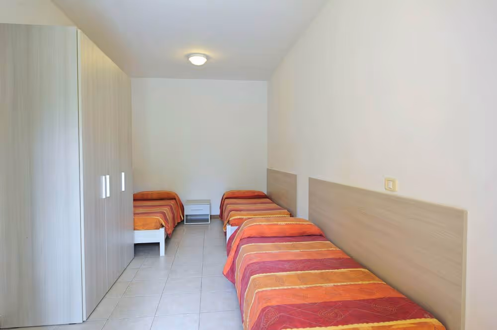 Slaapkamer met twee bedden in een appartement op Camping Bella Italia