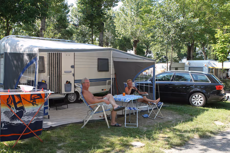 Caravan met voortent op een schaduwrijke staanplaats van Camping Bella Italia