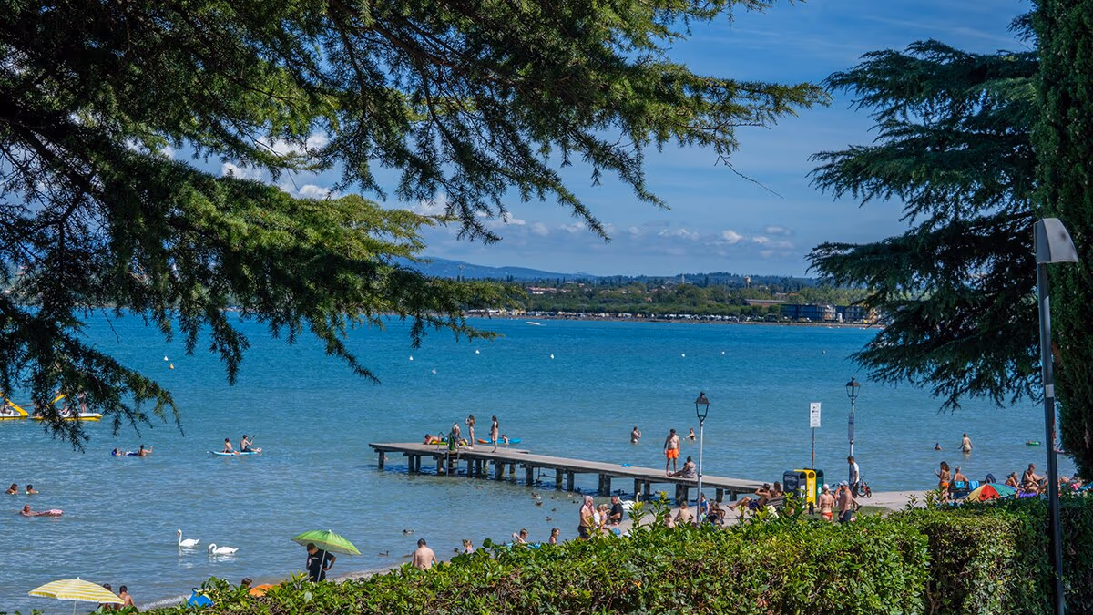 Houten steiger met zwemmers aan het Gardameer bij Camping Bella Italia