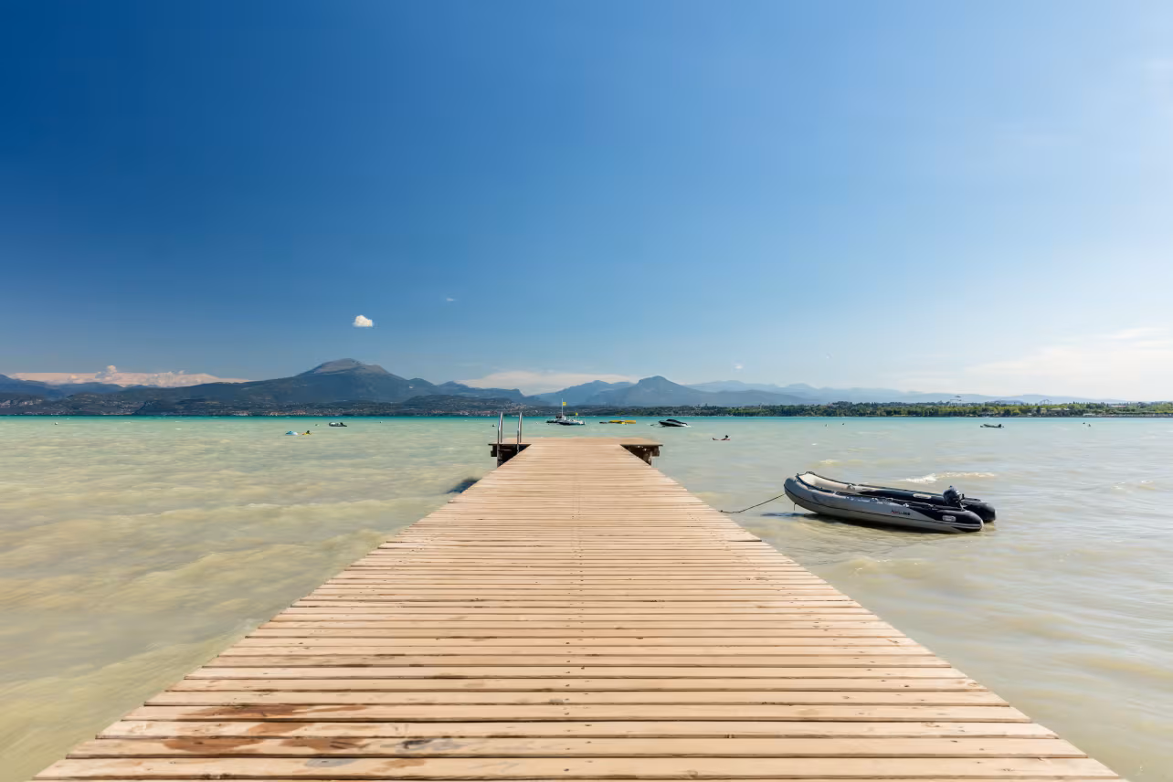 Houten steiger aan het Gardameer bij Camping Bella Italia met uitzicht op de bergen