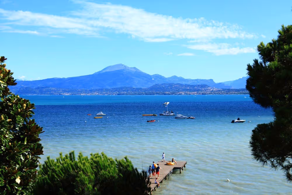 Strandzone aan het Gardameer bij Camping Bella Italia met gasten aan het water