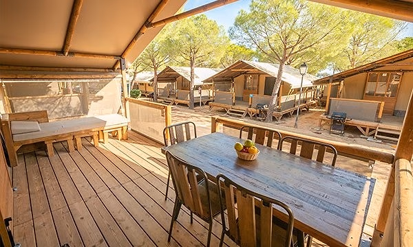 Houten terras met grote eettafel van een Super Lodge op Camping Bella Italia
