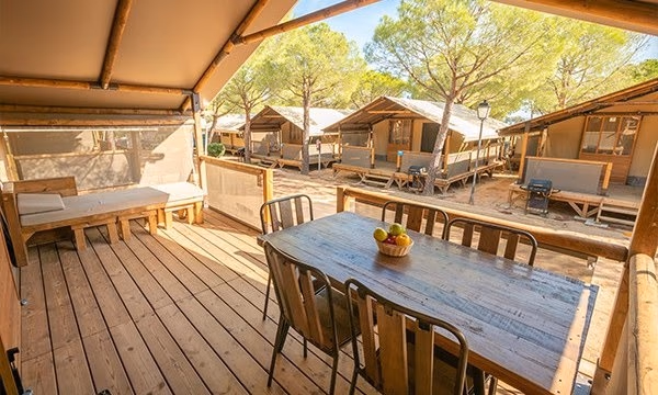 Houten terras met eettafel bij een lodgetent op Camping Bella Italia
