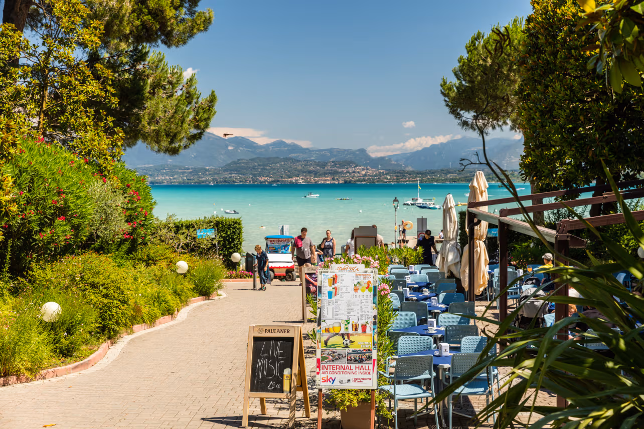 Terras met uitzicht op de campingweg en het Gardameer bij Camping Bella Italia