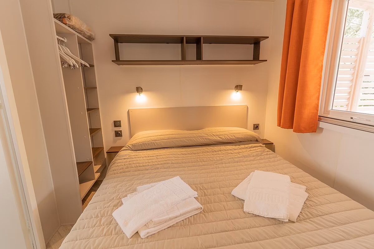 Tweepersoonsslaapkamer in een stacaravan van Camping Bella Italia