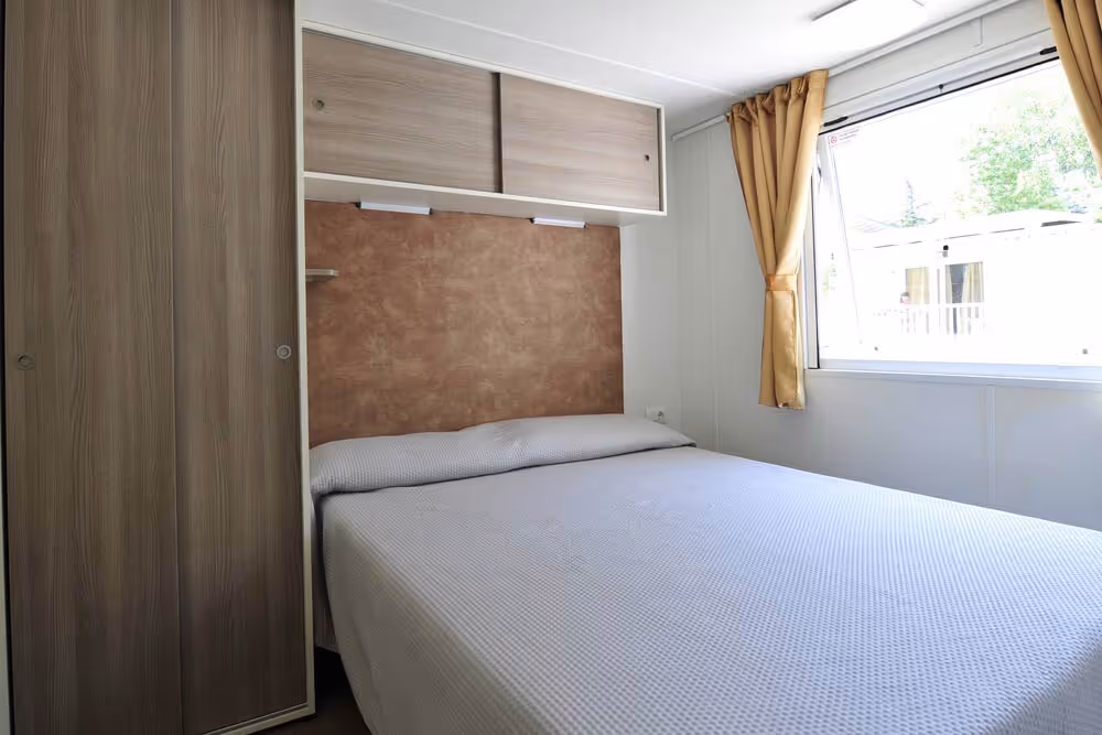 Tweepersoonsslaapkamer in een mobile home op Camping Bella Italia