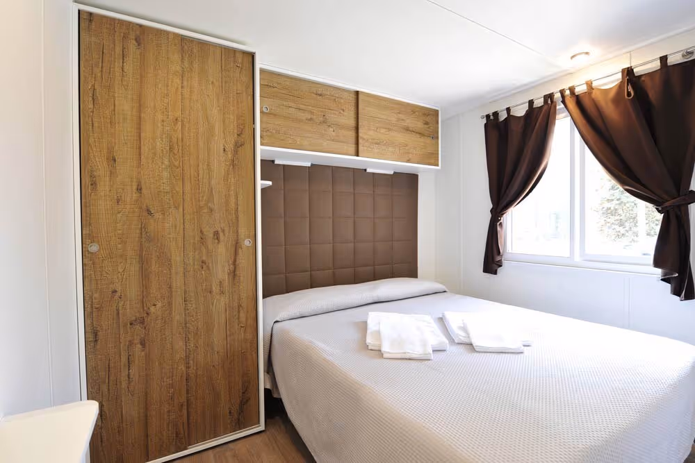 Ruime tweepersoonsslaapkamer in een stacaravan van Camping Bella Italia