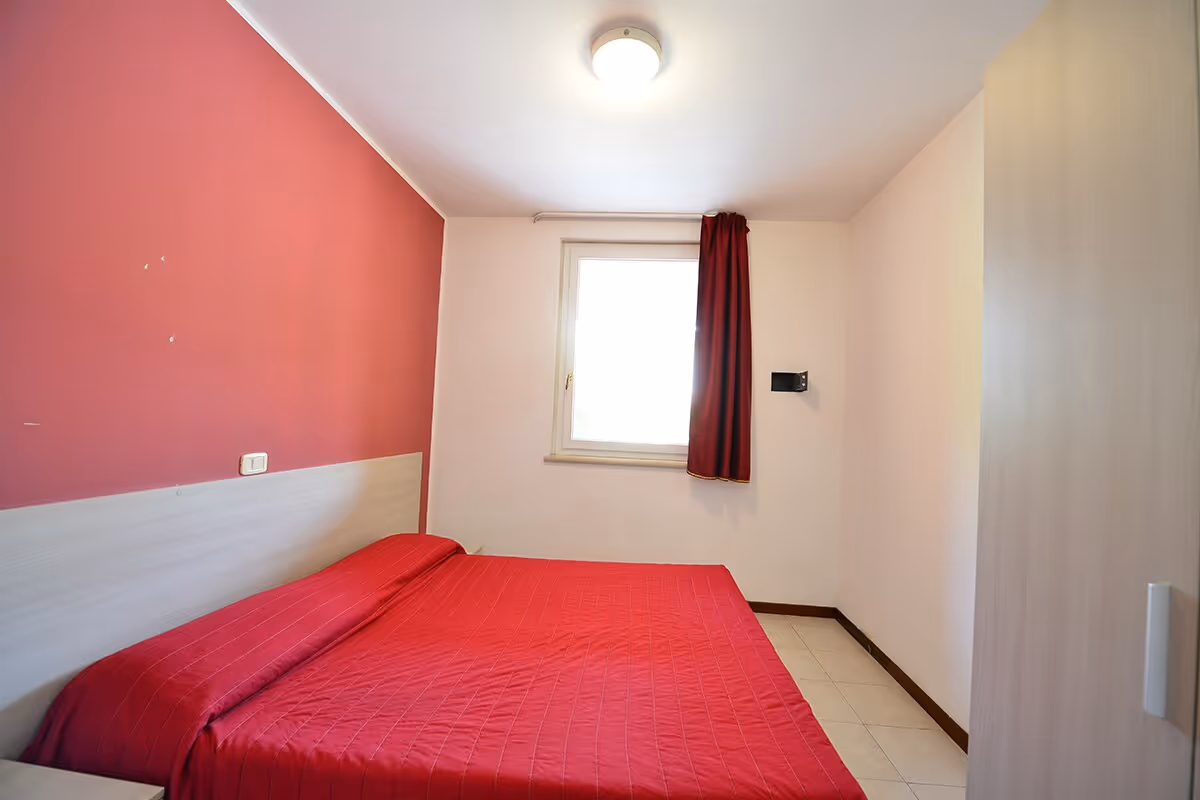 Tweepersoonsslaapkamer in een appartement van Camping Bella Italia