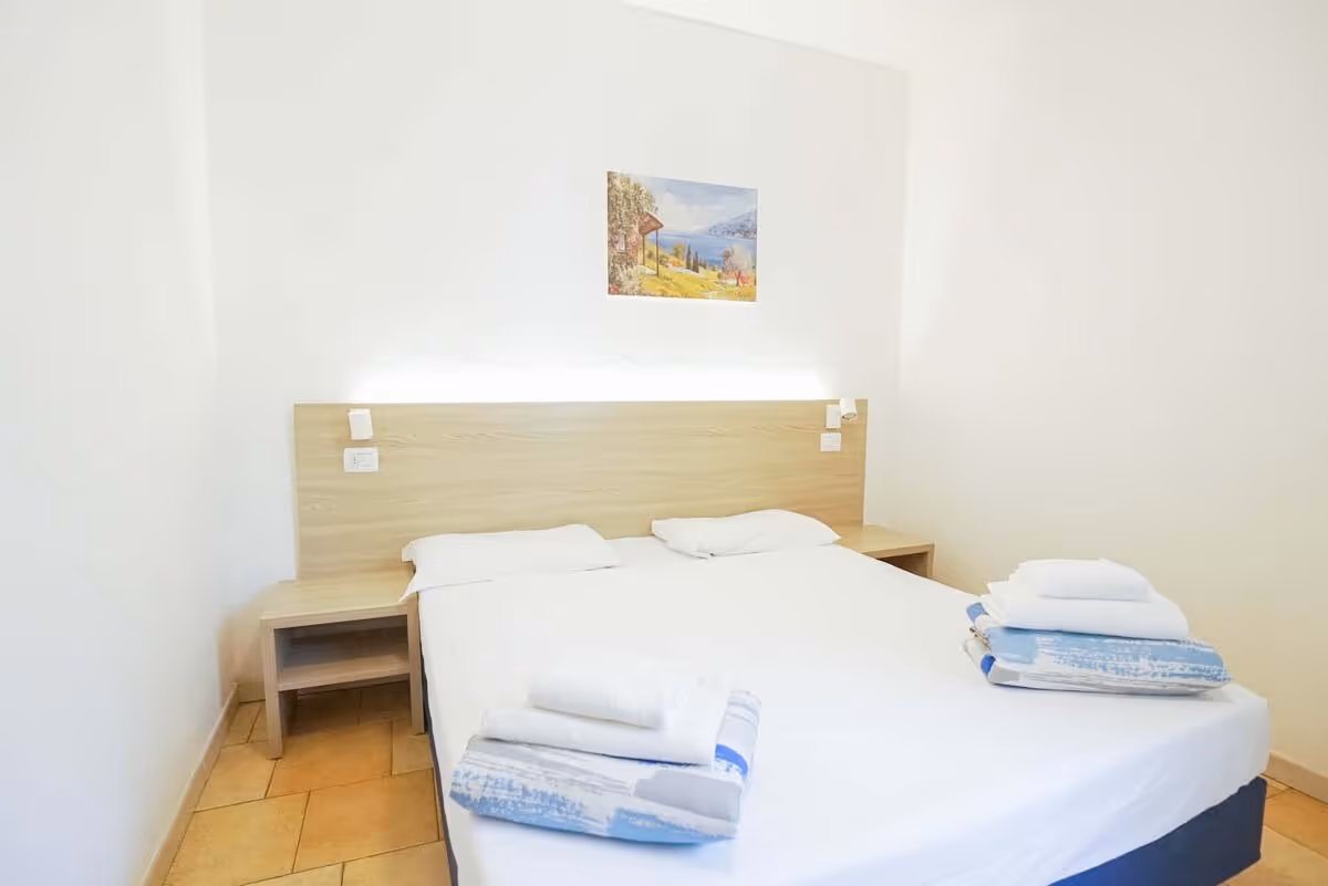 Tweepersoonsslaapkamer in een bungalow van Camping Bella Italia