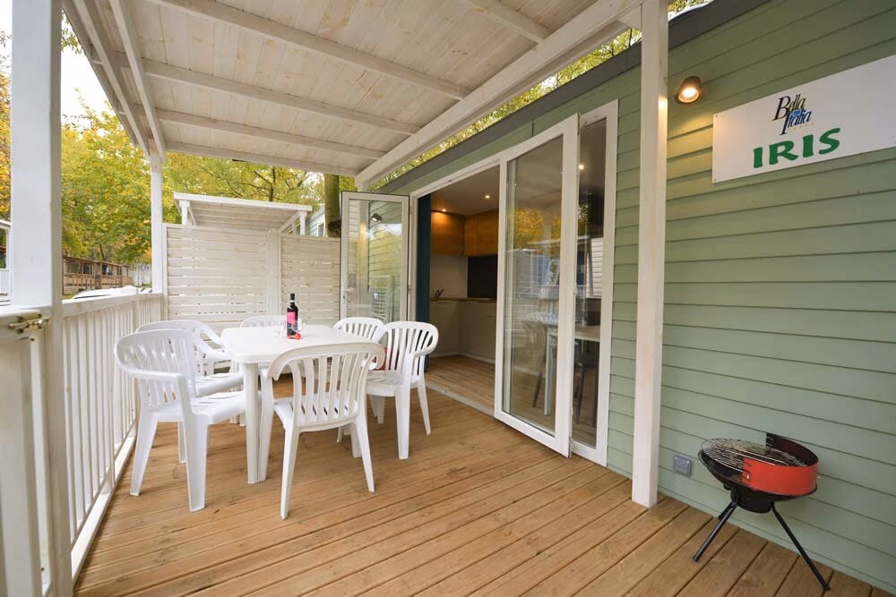 Veranda met stoelen en tafel bij een stacaravan op Camping Bella Italia