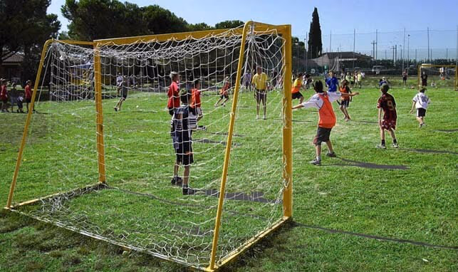 Kinderen voetballen tijdens een sportactiviteit op het veld van Camping Bella Italia aan het Gardameer