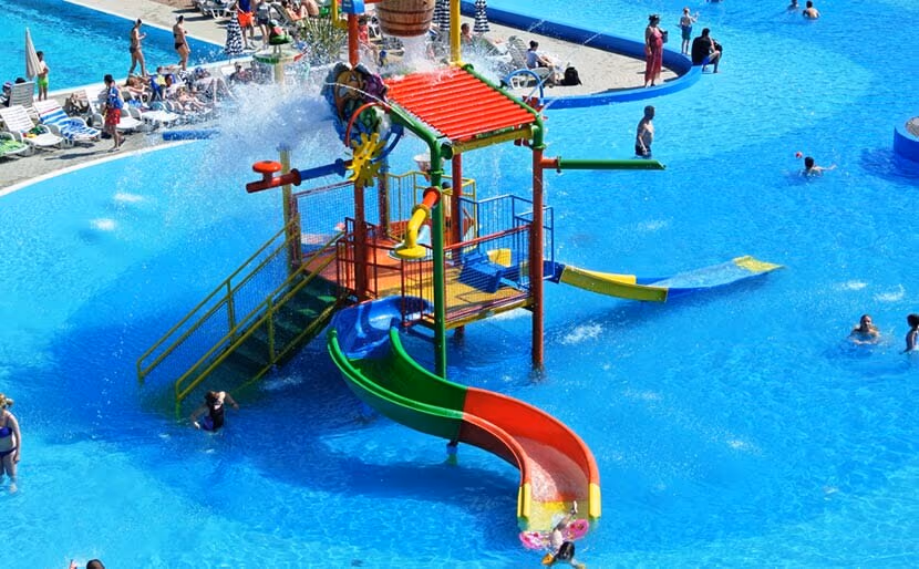 Kleurrijke glijbaan en waterspeeltoestel in het kinderbad van Camping Bella Italia