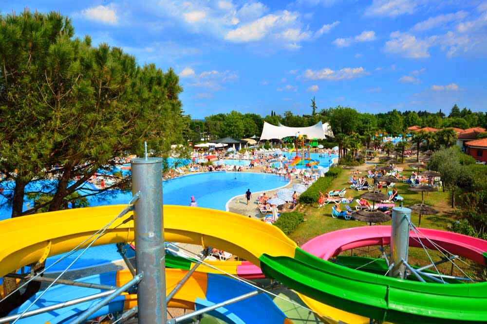 Bochtige waterglijbanen hoog boven de zwembaden van het aquapark van Camping Bella Italia