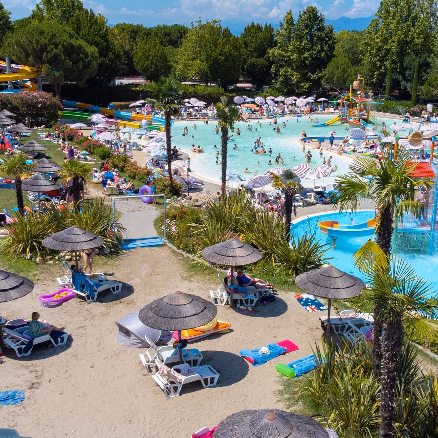 Overzicht van de zwembaden, ligbedden en parasols in het aquapark van Camping Bella Italia