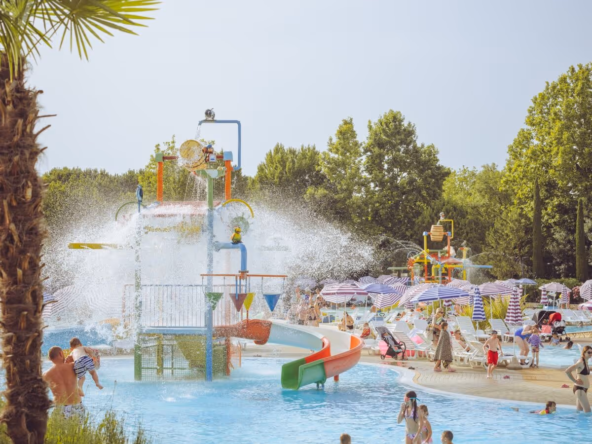 Groot waterspeeltoestel met glijbanen en fonteinen in het aquapark van Camping Bella Italia