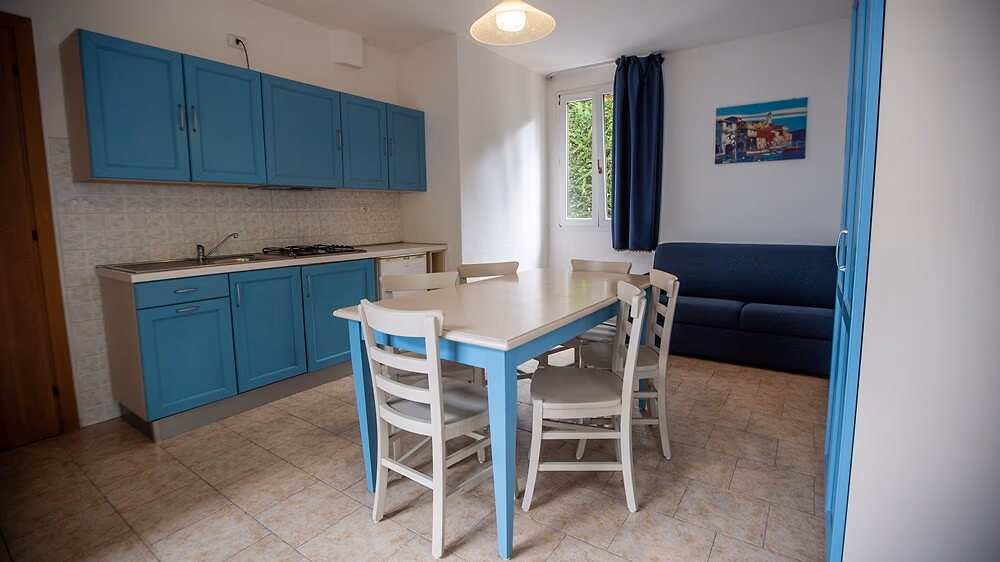 Woonkeuken met blauwe kastjes in appartement Ortensia op Camping Bella Italia